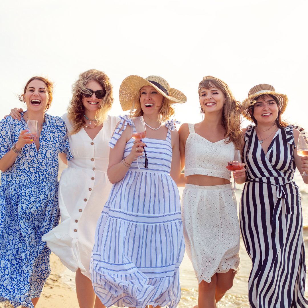 group of women on beach drinking champagne